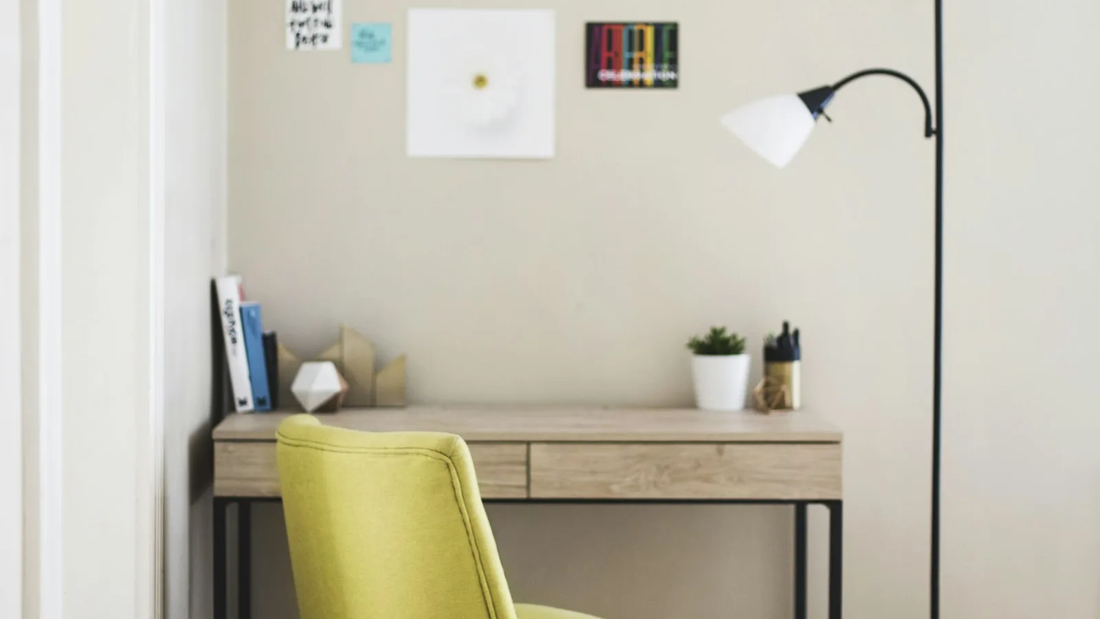 Petit bureau installé dans un angle de salon avec chaise et lampe